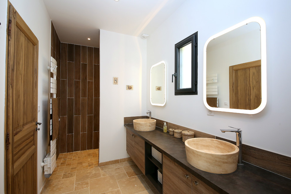 Inspiration för ett medelhavsstil brun brunt badrum med dusch, med luckor med profilerade fronter, bruna skåp, ett undermonterat badkar, en kantlös dusch, en vägghängd toalettstol, vita väggar, ett konsol handfat, brunt golv och med dusch som är öppen