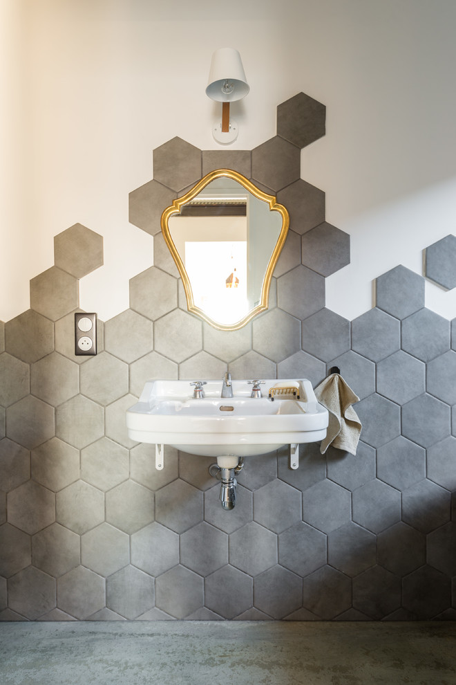 Foto på ett mellanstort funkis badrum, med grå kakel, vita väggar, betonggolv och ett väggmonterat handfat