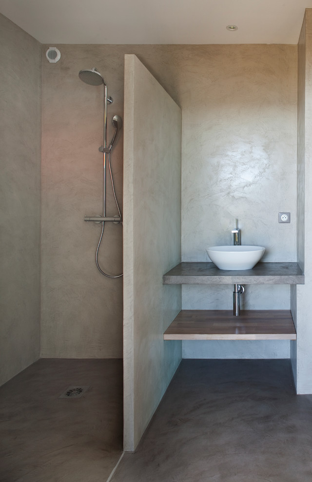Idéer för funkis badrum med dusch, med ett fristående handfat, öppna hyllor, skåp i mellenmörkt trä, träbänkskiva, grå väggar, betonggolv och en kantlös dusch