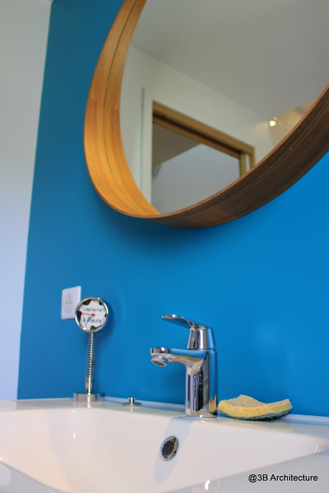 Idée de décoration pour une petite salle de bain minimaliste pour enfant avec un placard à porte affleurante, des portes de placard blanches, une baignoire encastrée, un carrelage blanc, des carreaux de céramique, un mur bleu, parquet clair et un plan vasque.
