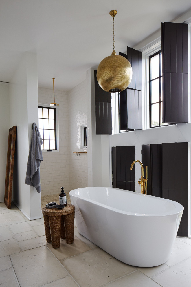 Foto på ett stort medelhavsstil en-suite badrum, med ett fristående badkar, en dusch i en alkov, vit kakel, tunnelbanekakel, beige väggar, beiget golv och med dusch som är öppen