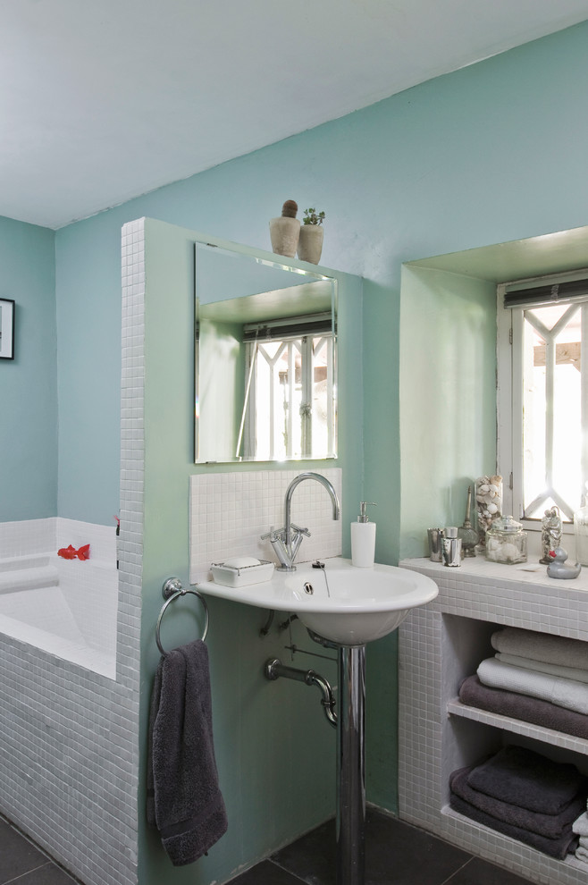 На фото: главная ванная комната среднего размера в современном стиле с раковиной с пьедесталом, открытыми фасадами, ванной в нише, белой плиткой, белыми фасадами и синими стенами