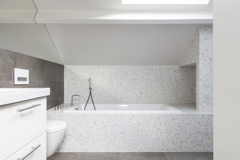 На фото: главная ванная комната среднего размера в современном стиле с полновстраиваемой ванной, душем без бортиков, белой плиткой, мраморной плиткой, белыми стенами, полом из терракотовой плитки, консольной раковиной, мраморной столешницей, серым полом, открытым душем и белой столешницей с