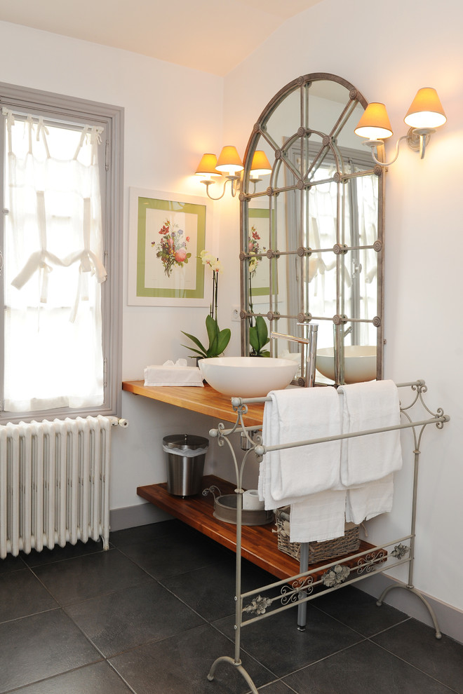 Réalisation d'une salle de bain champêtre en bois brun de taille moyenne avec une vasque, un plan de toilette en bois et un mur blanc.