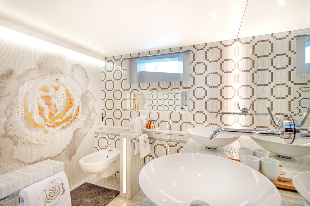 Inredning av ett modernt vit vitt badrum, med flerfärgad kakel, mosaikgolv, ett fristående handfat, kaklad bänkskiva och vitt golv