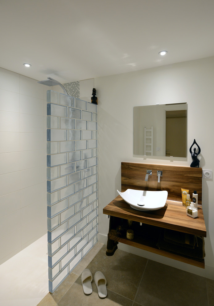 Idee per una stanza da bagno con doccia minimalista di medie dimensioni con doccia a filo pavimento, piastrelle beige, piastrelle in ceramica, pareti beige, lavabo da incasso, top in legno, pavimento con piastrelle in ceramica e pavimento beige