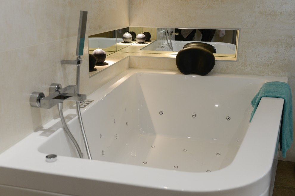 Diseño de cuarto de baño principal contemporáneo grande con lavabo tipo consola, encimera de cemento, jacuzzi, ducha a ras de suelo, baldosas y/o azulejos beige y paredes beige