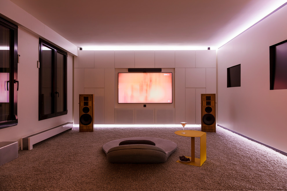This is an example of a medium sized contemporary enclosed home cinema in Paris with white walls, carpet, a wall mounted tv and grey floors.