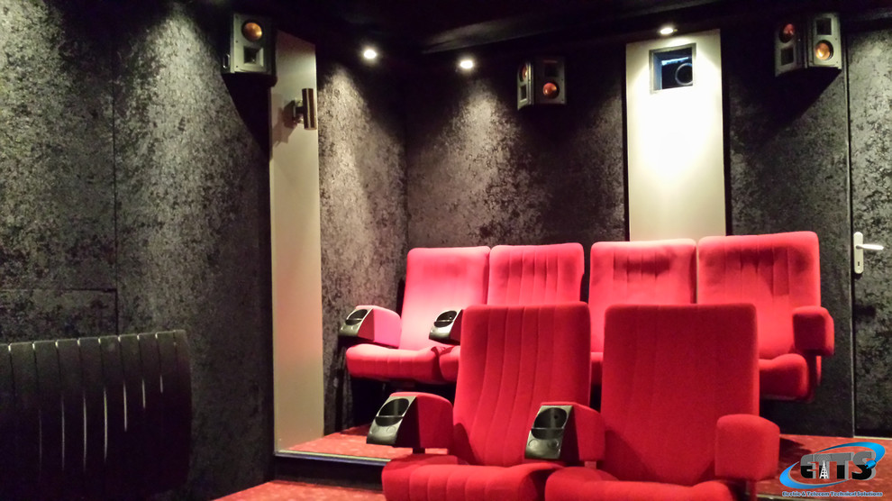 На фото: изолированный домашний кинотеатр в стиле модернизм с черными стенами, ковровым покрытием, проектором и красным полом