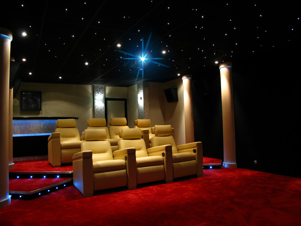 Пример оригинального дизайна: изолированный домашний кинотеатр в современном стиле с черными стенами и красным полом