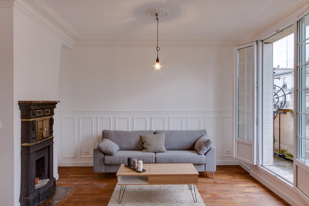 Foto di un soggiorno minimal con pareti bianche, parquet scuro e camino classico