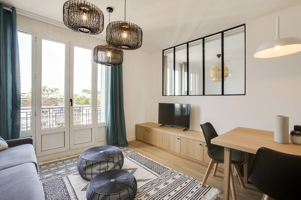 Photo of a medium sized scandi open plan games room in Paris with white walls, light hardwood flooring and a freestanding tv.
