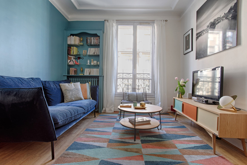 Immagine di un soggiorno scandinavo di medie dimensioni e chiuso con pareti blu e parquet chiaro