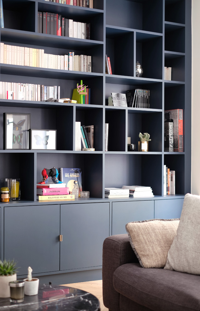 Exemple d'une grande salle de séjour tendance ouverte avec une bibliothèque ou un coin lecture, un mur gris, parquet clair, un téléviseur fixé au mur et un sol beige.