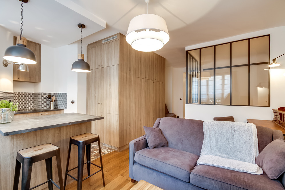 Modelo de sala de estar abierta industrial pequeña sin chimenea con paredes blancas, suelo de madera clara y televisor independiente