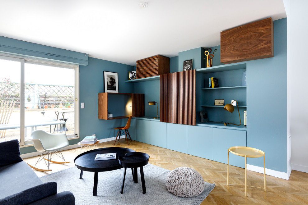 Réalisation d'une salle de séjour design avec un mur bleu, parquet clair et aucune cheminée.