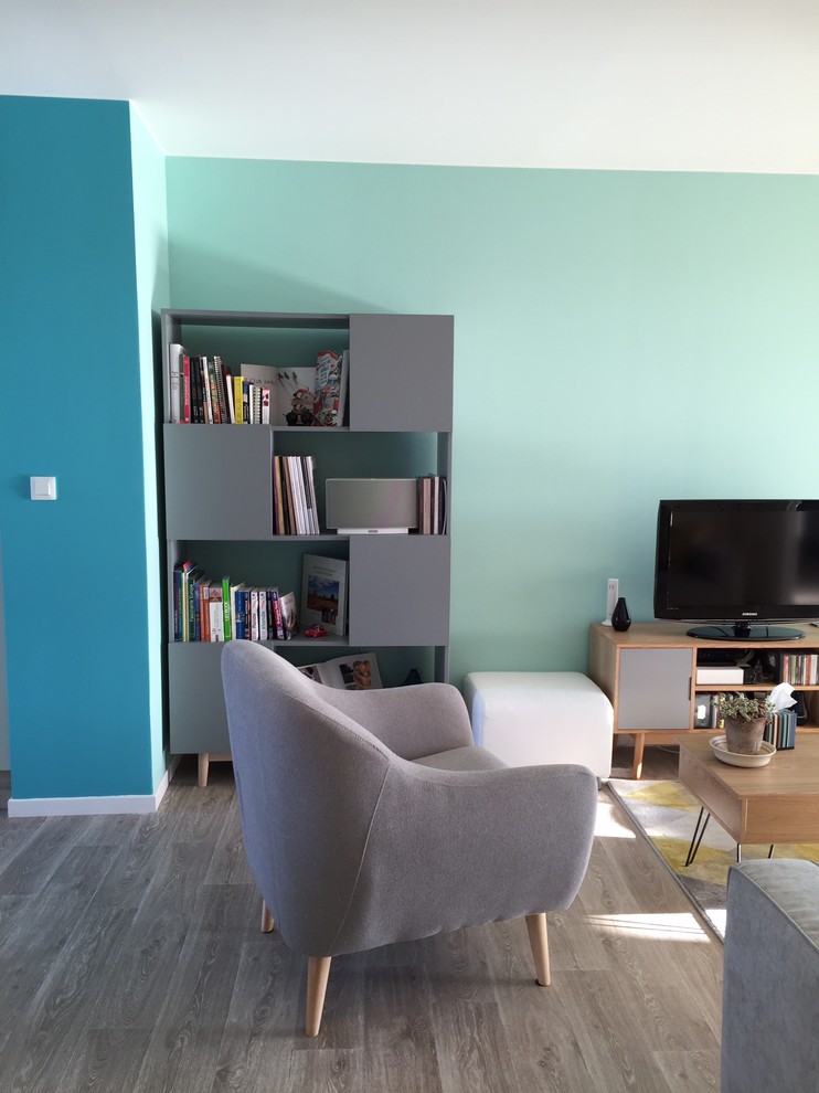 Cette image montre une salle de séjour nordique avec un mur bleu et parquet clair.