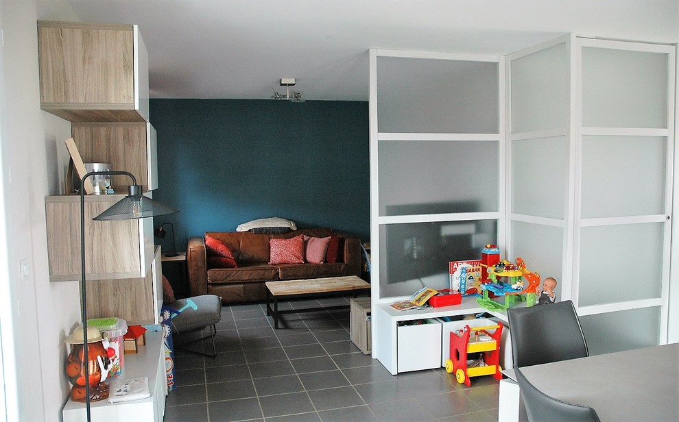 Exemple d'une salle de séjour tendance de taille moyenne et ouverte avec un mur vert, un sol en carrelage de céramique, un téléviseur d'angle et un sol gris.