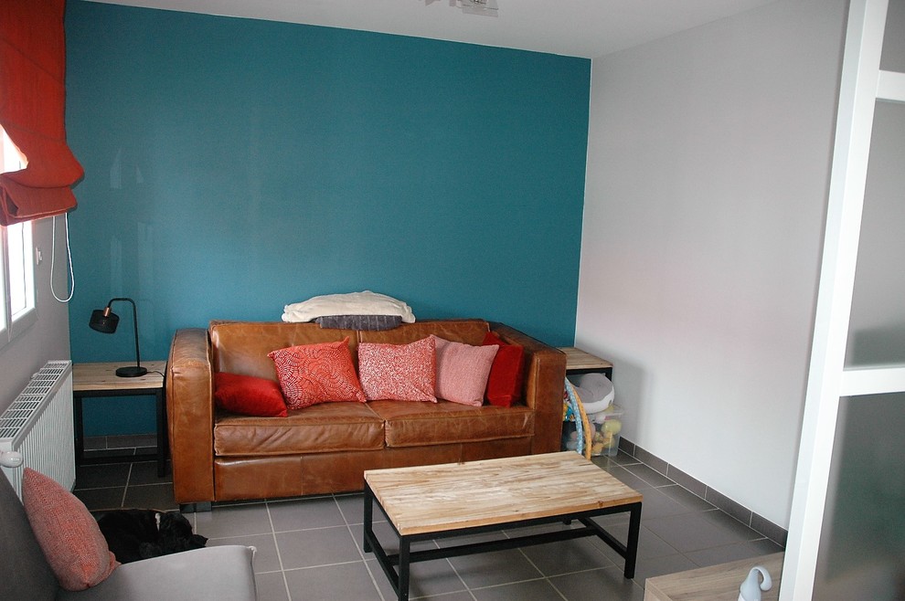 Immagine di un soggiorno design di medie dimensioni e aperto con pareti verdi, pavimento con piastrelle in ceramica, porta TV ad angolo e pavimento grigio
