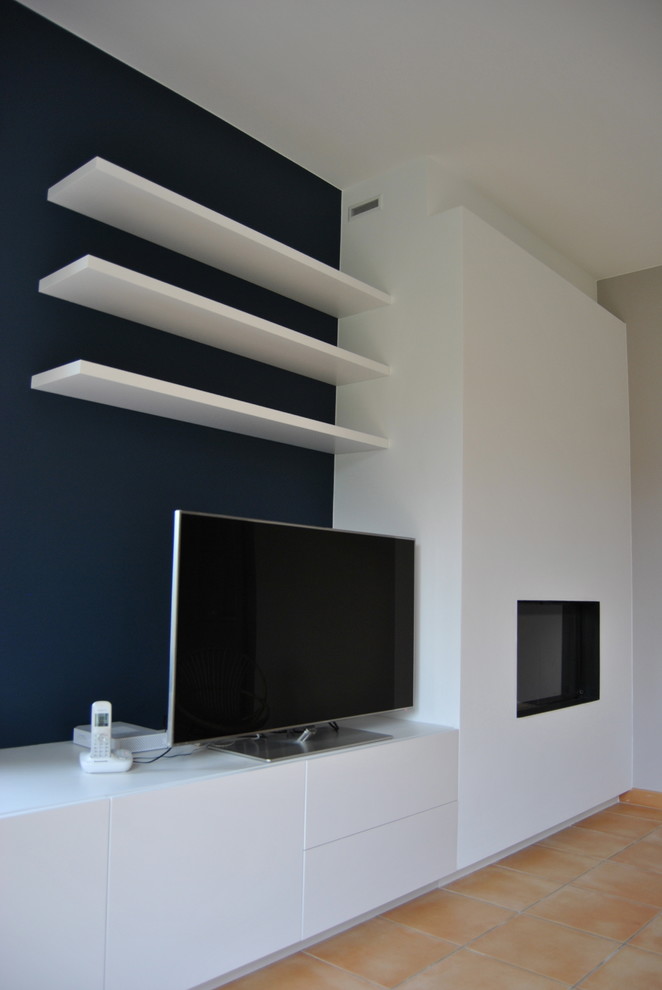 Inspiration pour une salle de séjour minimaliste de taille moyenne et ouverte avec tomettes au sol, une cheminée standard, un téléviseur indépendant et un mur bleu.