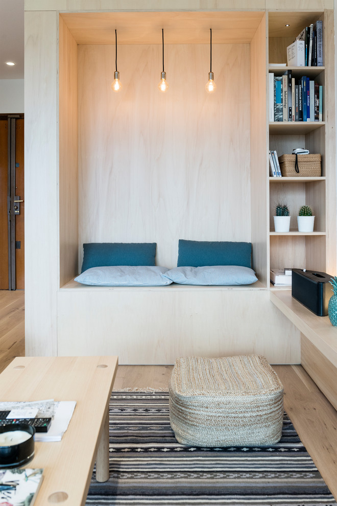 Inspiration för minimalistiska allrum, med ett bibliotek och ljust trägolv
