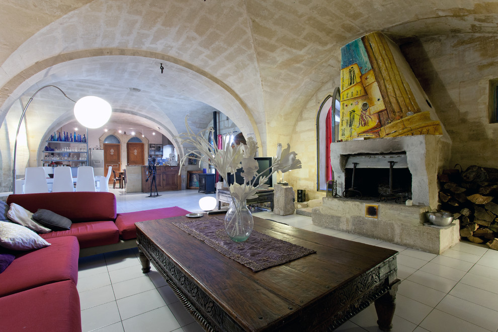 モンペリエにある地中海スタイルのおしゃれなファミリールーム (セラミックタイルの床、標準型暖炉、石材の暖炉まわり) の写真