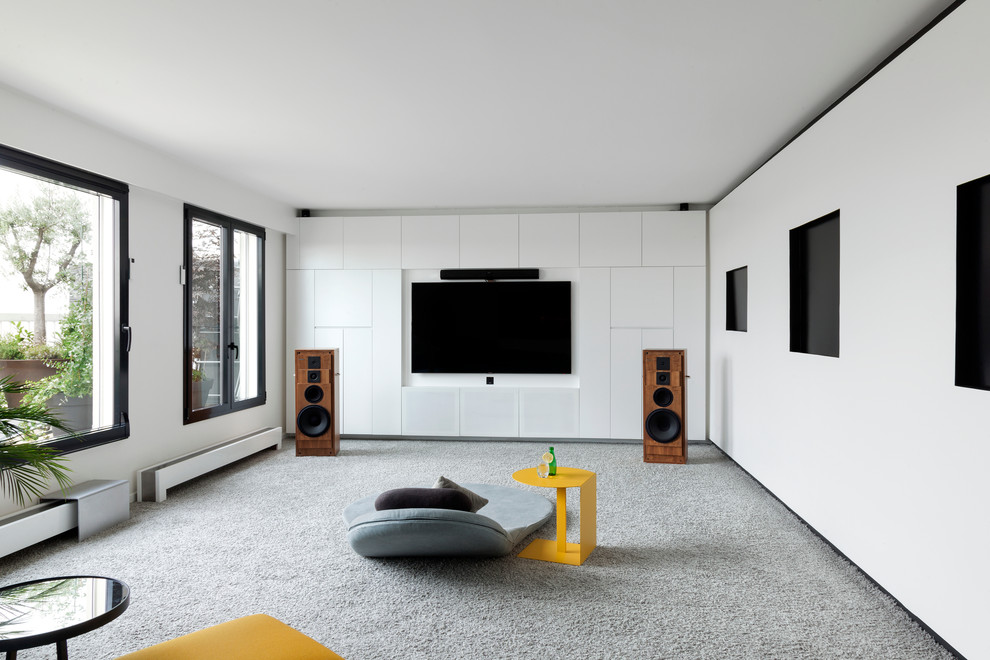 Diseño de sala de estar cerrada actual de tamaño medio sin chimenea con paredes blancas, moqueta, televisor colgado en la pared y suelo gris