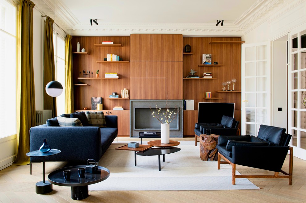 Immagine di un grande soggiorno minimal chiuso con libreria, parquet chiaro e camino classico