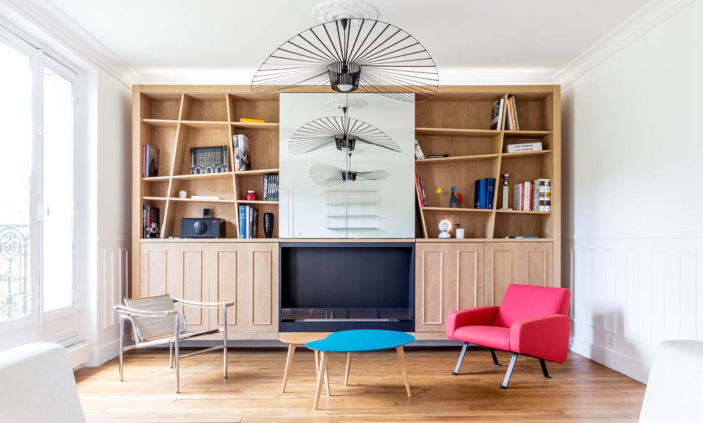 Foto di un soggiorno design di medie dimensioni e aperto con pareti bianche, camino classico, TV nascosta, libreria e pavimento in legno massello medio