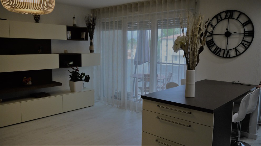 Immagine di un soggiorno contemporaneo di medie dimensioni e aperto con pareti bianche, pavimento in laminato e parete attrezzata