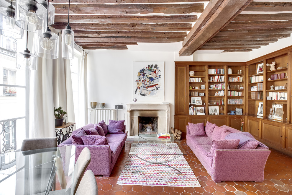 Источник вдохновения для домашнего уюта: гостиная комната в средиземноморском стиле с с книжными шкафами и полками, белыми стенами, полом из терракотовой плитки и стандартным камином