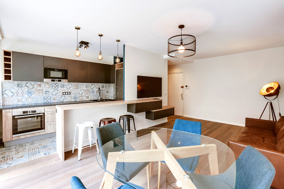 Geräumiges Industrial Wohnzimmer mit Hausbar, weißer Wandfarbe, hellem Holzboden und TV-Wand in Paris