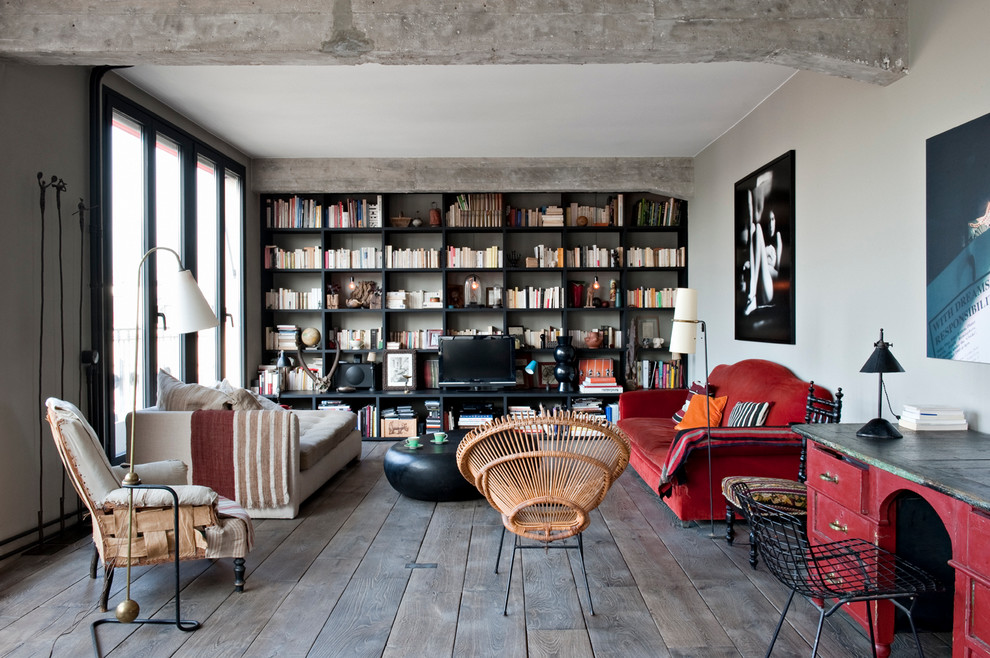 Mittelgroße, Abgetrennte Industrial Bibliothek ohne Kamin mit grauer Wandfarbe, dunklem Holzboden und freistehendem TV in Paris
