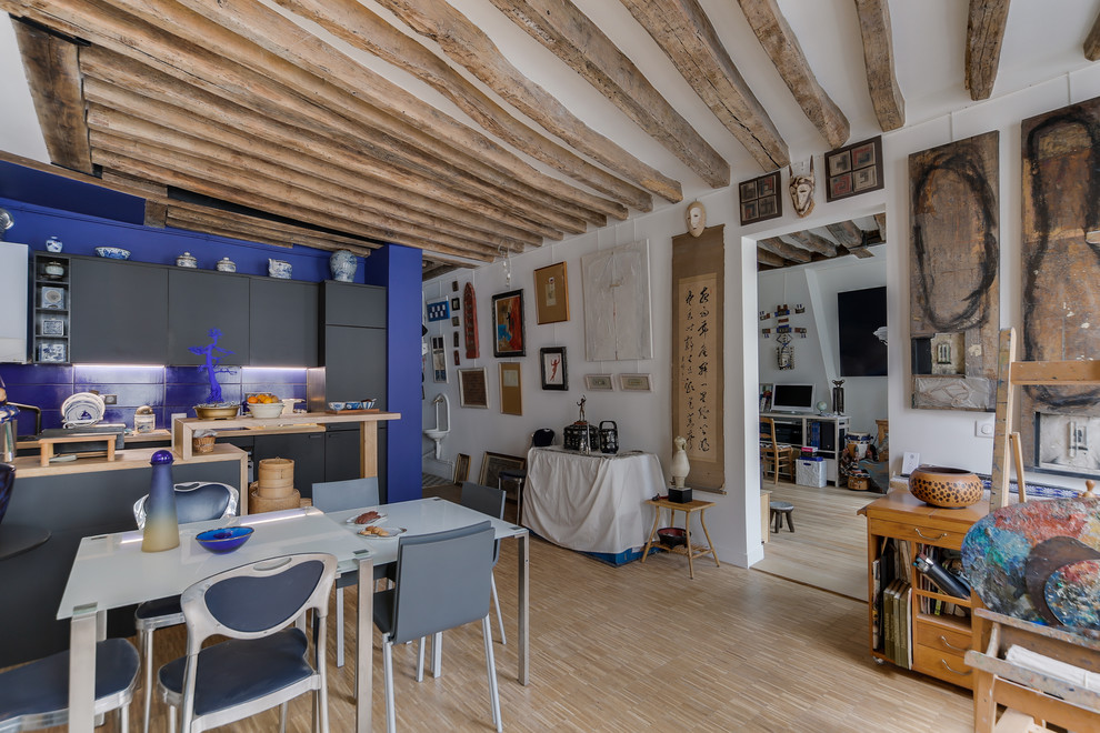 Réalisation d'une grande salle de séjour ethnique ouverte avec un mur blanc, parquet clair, un sol beige, aucune cheminée et aucun téléviseur.