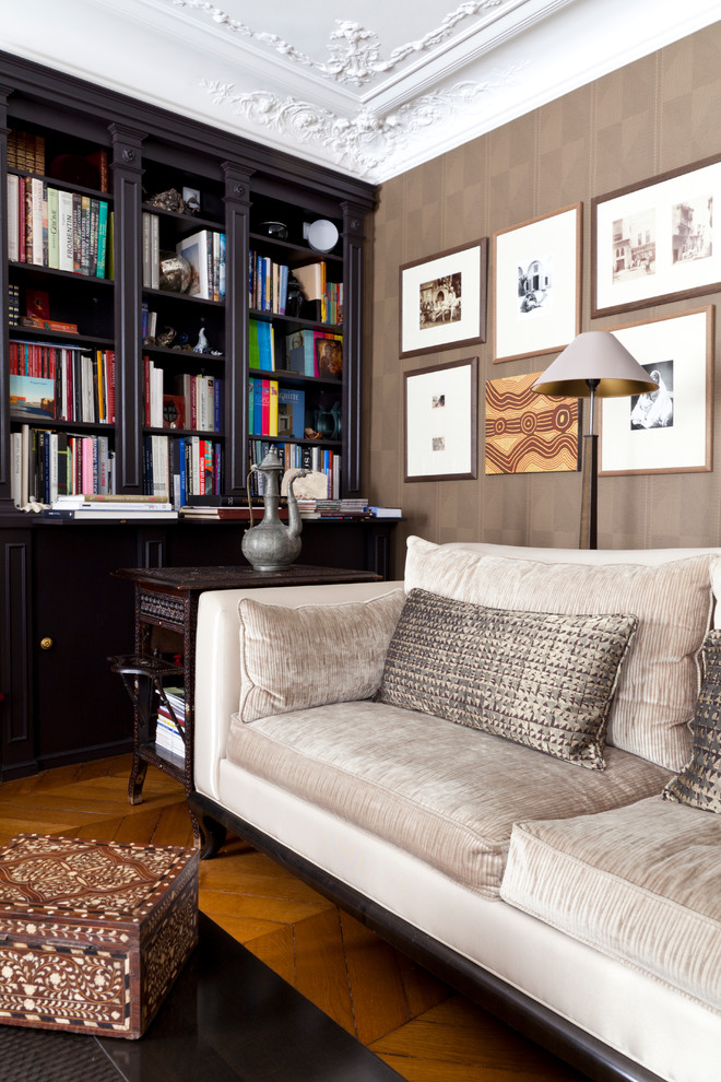 Modelo de sala de estar con biblioteca cerrada ecléctica de tamaño medio sin chimenea y televisor con paredes marrones y suelo de madera en tonos medios