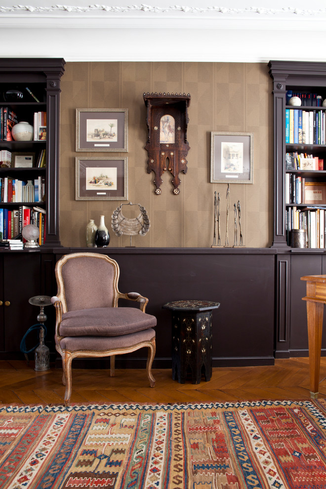 Ejemplo de sala de estar con biblioteca cerrada ecléctica de tamaño medio sin chimenea y televisor con paredes marrones y suelo de madera en tonos medios