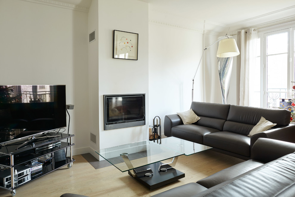 Inspiration pour une salle de séjour design de taille moyenne et fermée avec un mur blanc, parquet clair, un téléviseur indépendant, une cheminée standard et canapé noir.