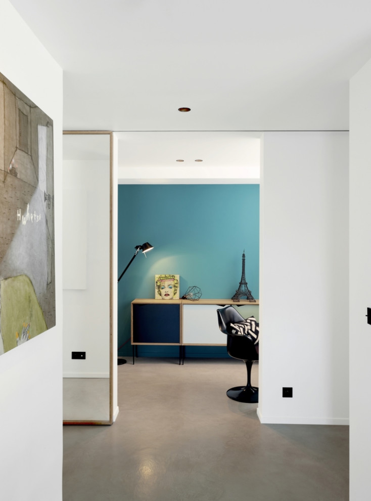 Immagine di un soggiorno design con pareti blu e pavimento grigio