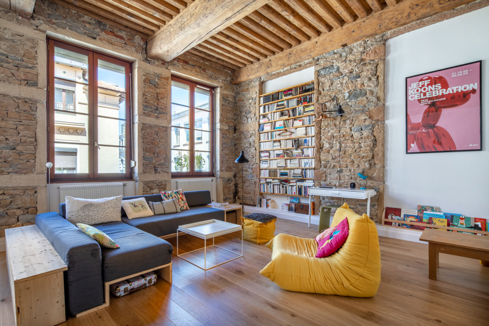 Fernseherloses Modernes Wohnzimmer mit Sperrholzboden und freigelegten Dachbalken in Lyon