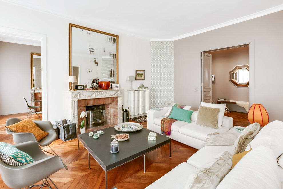 Cette photo montre une grande salle de séjour moderne ouverte avec un mur beige, un sol en bois brun, une cheminée standard, un manteau de cheminée en pierre et un sol marron.