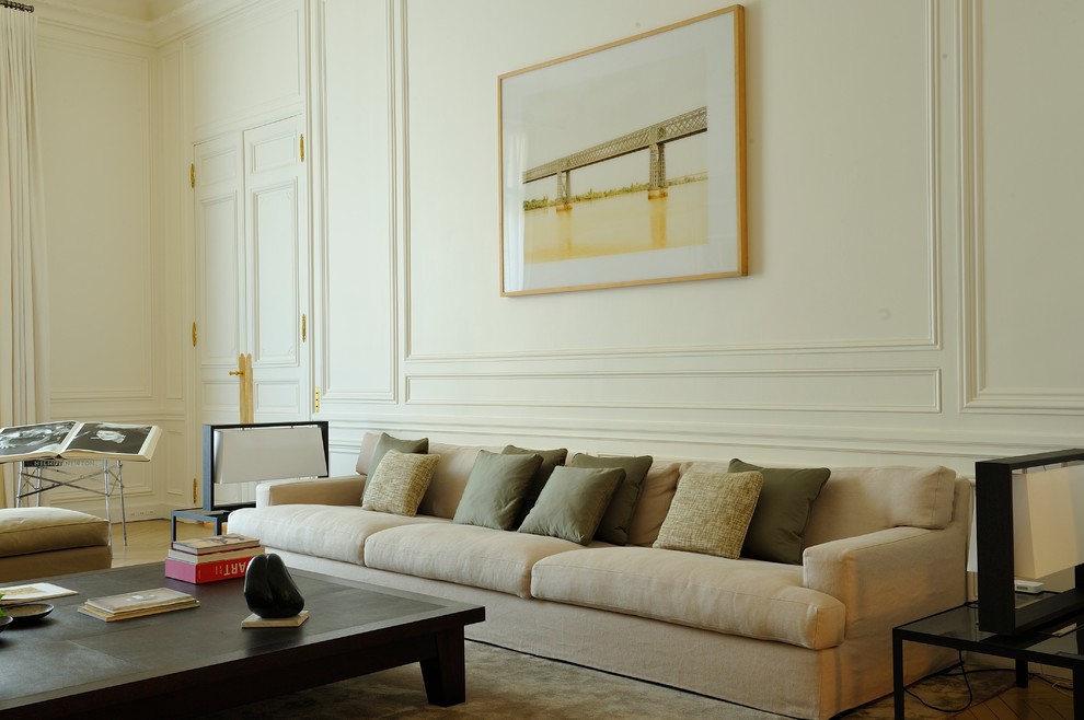Réalisation d'une salle de séjour design de taille moyenne et fermée avec un mur blanc, parquet clair, une bibliothèque ou un coin lecture et un sol beige.