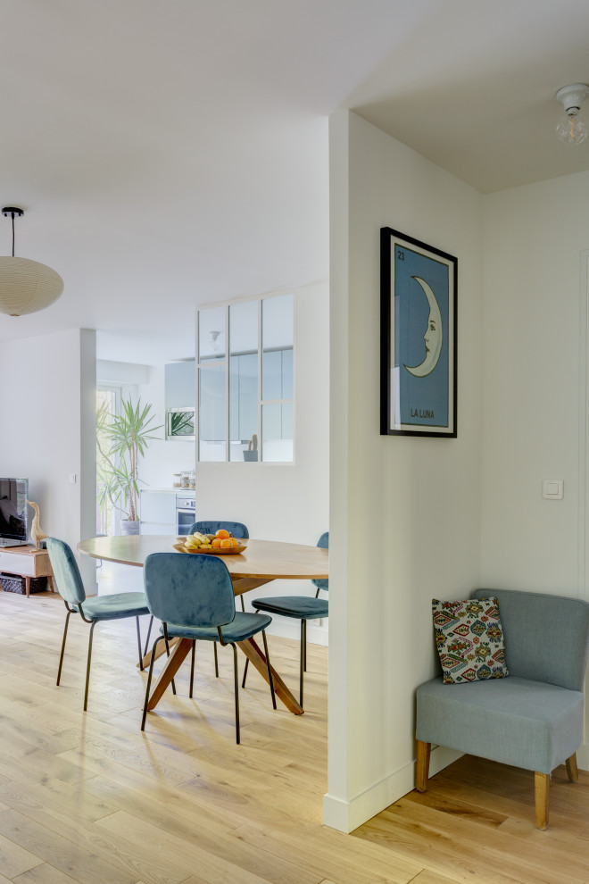 Diseño de sala de estar abierta moderna grande sin chimenea con paredes blancas, suelo de madera clara, suelo marrón y televisor independiente