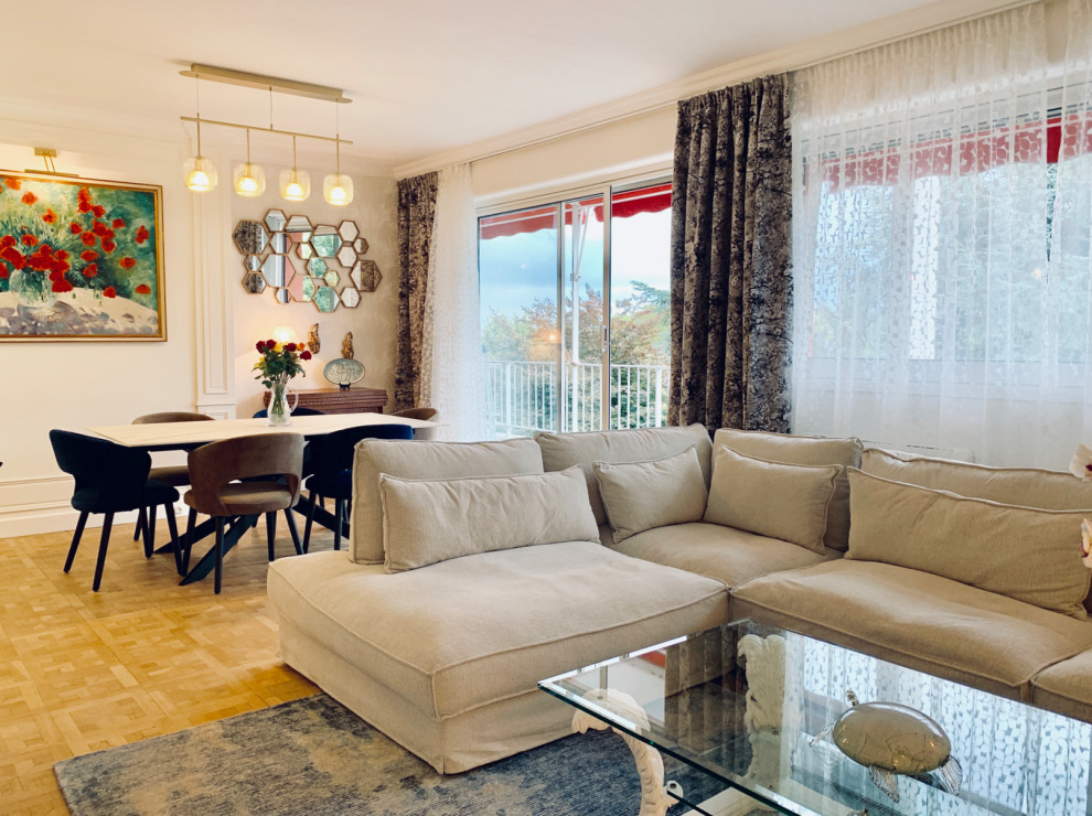 Cette photo montre une salle de séjour chic de taille moyenne et ouverte avec un mur beige, parquet clair, un téléviseur indépendant et un sol beige.