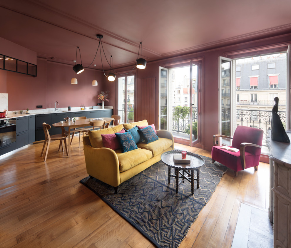 Foto de sala de estar abierta moderna grande con paredes rosas, suelo de madera en tonos medios, todas las chimeneas y suelo beige