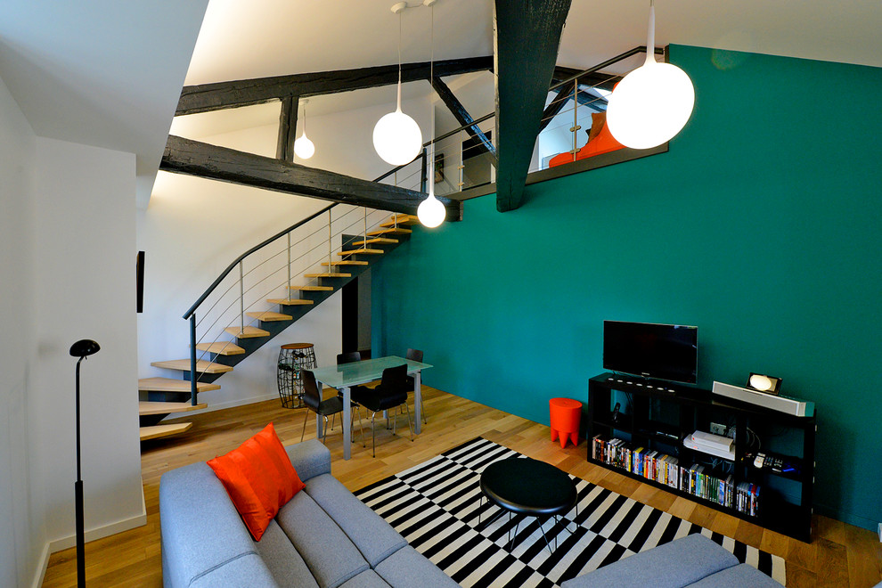 Inspiration pour une grande salle de séjour design avec un sol en bois brun, un téléviseur indépendant et un mur multicolore.
