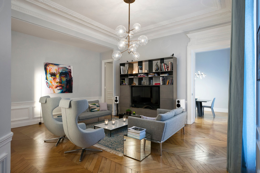 Diseño de sala de estar cerrada contemporánea grande sin chimenea con paredes grises, suelo de madera en tonos medios y televisor independiente