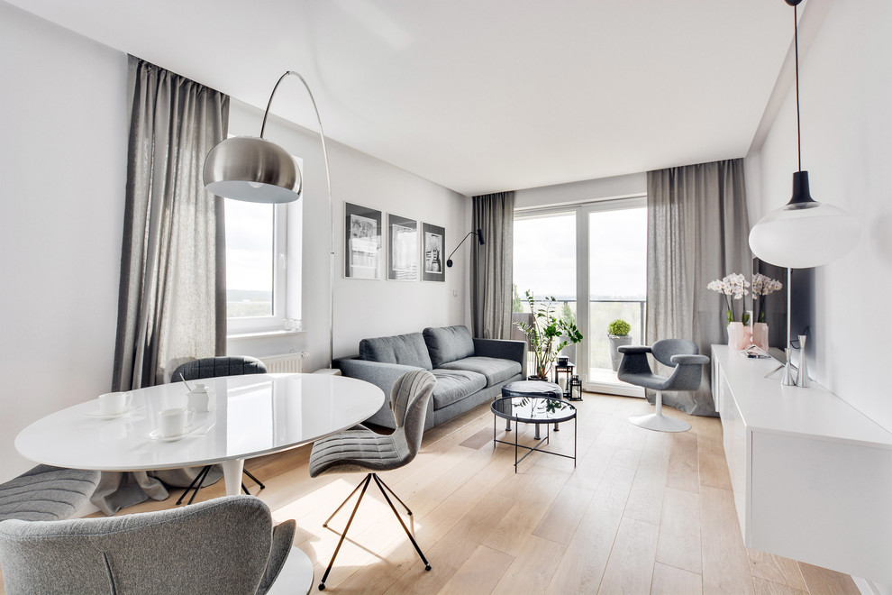 Diseño de sala de estar abierta contemporánea de tamaño medio con paredes grises, suelo de madera clara, suelo beige y televisor independiente