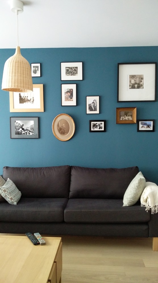 На фото: открытая гостиная комната среднего размера в скандинавском стиле с с книжными шкафами и полками и синими стенами с