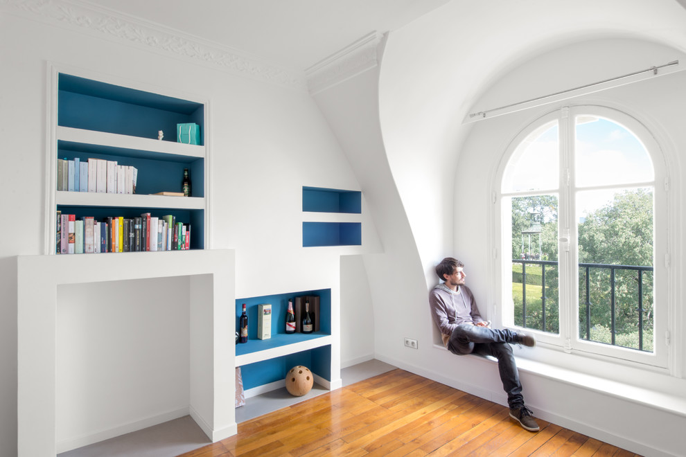 Inspiration för ett mellanstort funkis allrum med öppen planlösning, med ett bibliotek, blå väggar och mellanmörkt trägolv