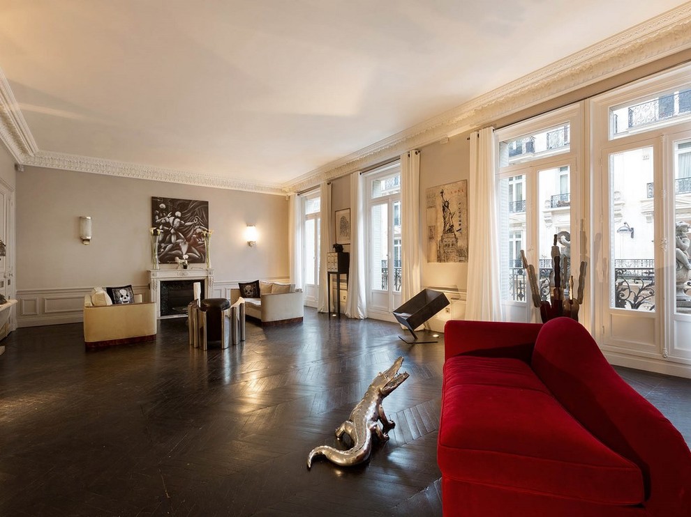 Geräumiges, Offenes Modernes Wohnzimmer mit beiger Wandfarbe, dunklem Holzboden, Kamin und Kaminumrandung aus Stein in Paris